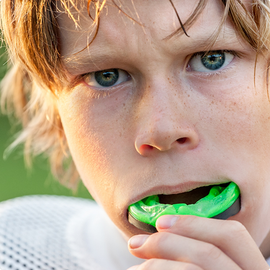 Close up of young football player putting in mouthguard