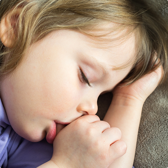 Close-up of child sucking their thumb