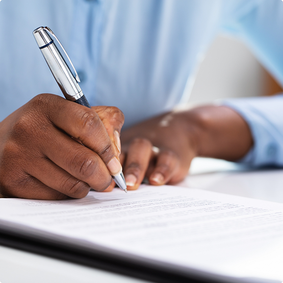 Close up of patient filling out forms with a pen