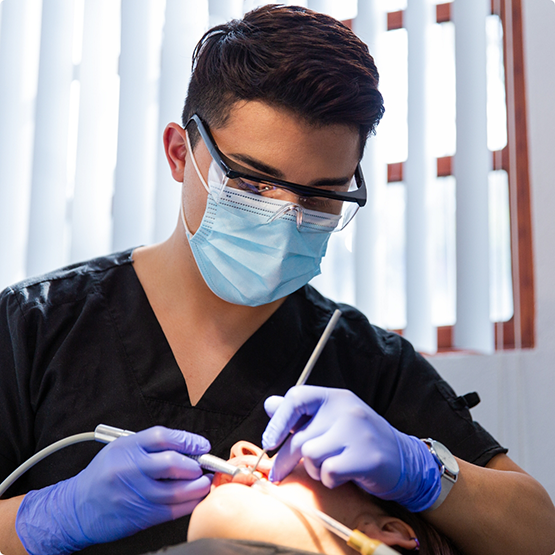 Dentist with mask and glasses performing gum disease treatment in Phoenix