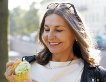 Woman with glasses on head looking at ice cream cone