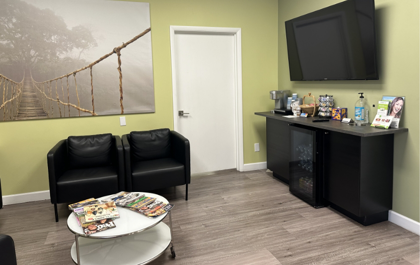 Table, chairs, shelf, and television in waiting room