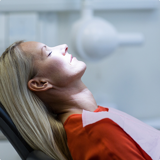 Female dental patient relaxing in dental chair