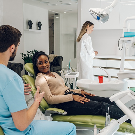 Dentist explaining cost of veneers to female patient